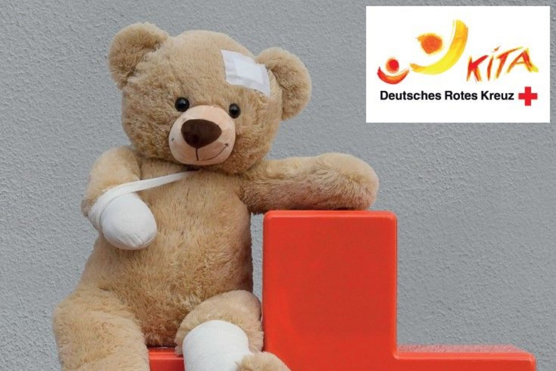 Kleiner bandagierter Teddy auf rotem Kreuz